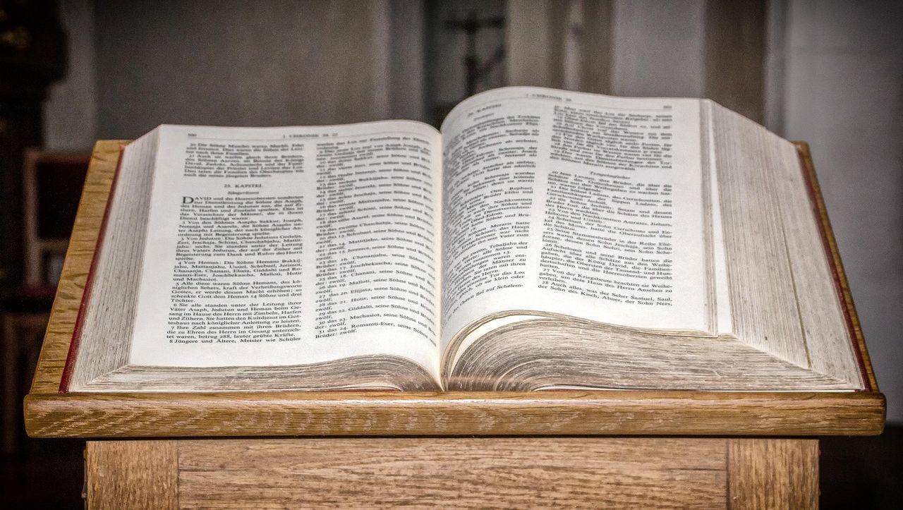 Aufgeschlagene Bibel auf einem hölzernen Lesepult in einem Gottesdienstraum